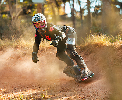 Onewheel rider carving a dirt corner at Amped
